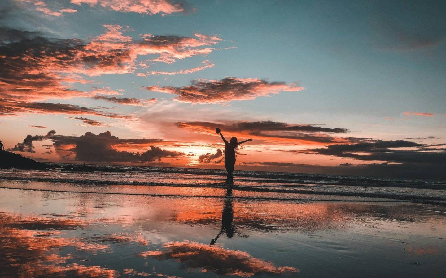 a woman on the beach at sunset