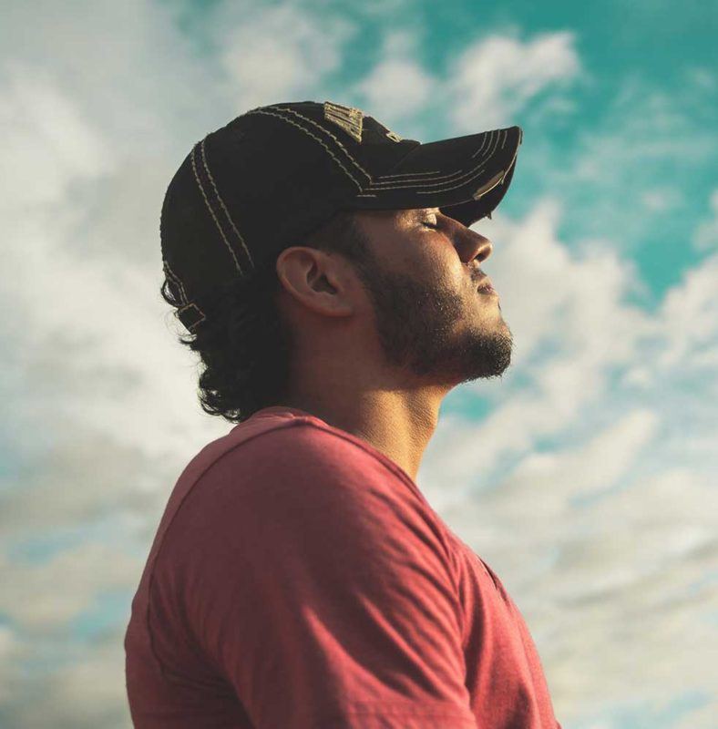 a man wearing a hat looking up into the sky