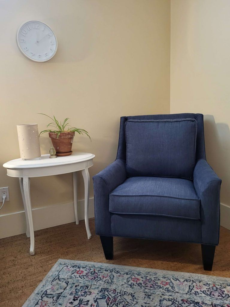 blue armchair next to a side table